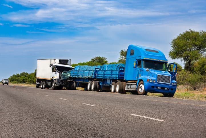 Truck accident on the highway with one semi-truck rear-ended by another.